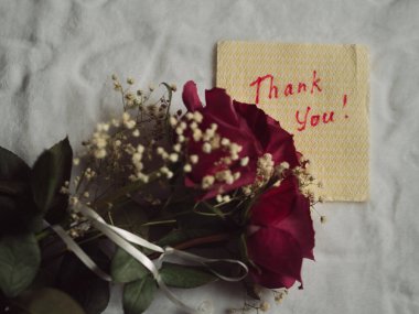 A Bouquet of Roses and a Handwritten 'Thank You' on a Paper Napkin, Isolated on White clipart