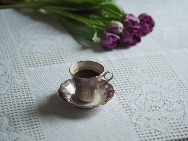 Klasik kahve kupası ve mor laleler, yatay natürmort