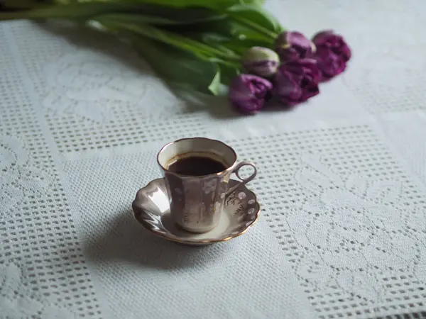 Klasik kahve kupası ve mor laleler, yatay natürmort