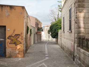 Olbia Eski Kasabası, Sardunya 'da Turuncu Graffigged Facade ve Ağaç ile Bir Çakıl Taşı Sokağı Yatay Geniş Açı Manzarası