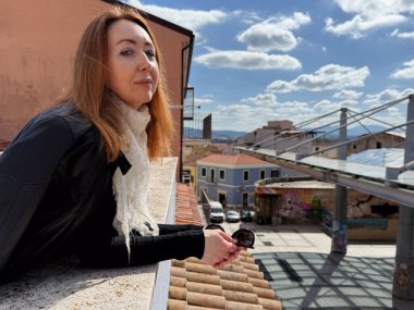 Kızıl saçlı kadın şehir manzarasının tadını çıkarıyor Piazza Mercato, Olbia, Sardinya 'daki Çatıdan