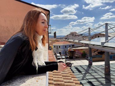 Olbia, Sardunya 'daki Çatı Terası' ndan Kızıl Saçlı Kadın Piazza Mercato 'ya Bakıyor