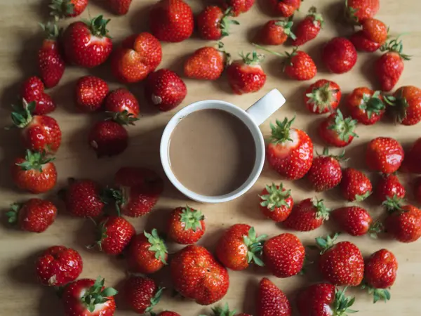 Tahta Masa üzerinde Sütlü ve Taze Çilekli Bir fincan Kahve - Yatay Düz Yatay