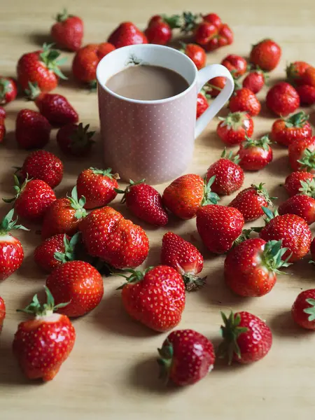 Tahta Masa üzerinde Sütlü ve Taze Çilekli Bir fincan Kahve - Dikey Durgun Hayat
