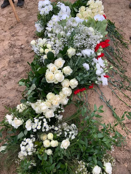 墓地の墓には花が並んでいる 墓の上には白と赤の花がたくさんあります コンセプト 愛する人の葬儀 — ストック写真