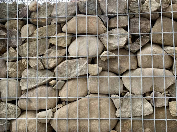 Achtergrondstructuur Rivierstenen Een Raster Muur Met Natuurstenen Een Metalen Frame — Stockfoto