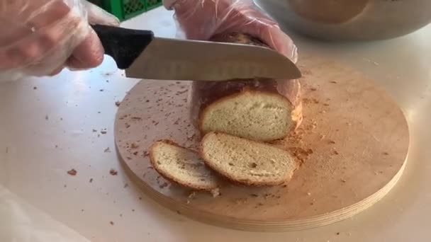 パンの新鮮なローフを切断するプロセス 女性は大きなナイフでパンを切る コンセプト 貧しい人々を助け 空腹を養う — ストック動画