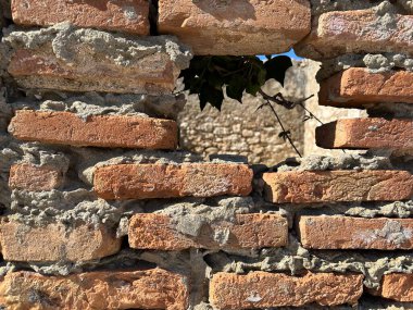 Hole in the ancient fortress wall. Ruins of an old fortress, a hole in the stone. Brick structure with a through hole clipart