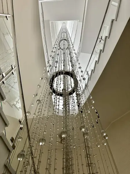 Large glass chandelier in the hotel. Crystal lamp between floors. A unique lamp in a multi-story building.