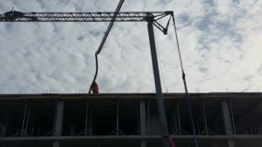 İnşaatçılar montaj vincinin arka planına karşı çalışıyorlar. Bir inşaat alanındaki işçiler, yüksek binaların inşaatının arka planına karşı. Lviv, St. Melnik, 20 Şubat 2024