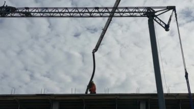 İnşaatçılar montaj vincinin arka planına karşı çalışıyorlar. Bir inşaat alanındaki işçiler, yüksek binaların inşaatının arka planına karşı. Lviv, St. Melnik, 20 Şubat 2024