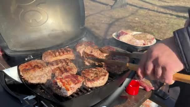 男はガスグリルで肉を調理する グリルで調理されるステーキ クローズアップ アウトドア ピクニック — ストック動画