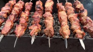 Izgarada şiş kebap yapıyorum. Izgarada kömür, şişte et ve barbekü. Doğada piknik, ateşte pişen domuz eti, ateşten çıkan duman..