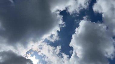 Bulutlar mavi gökyüzünde toplanıyor. Gökyüzü ve güneş gri bulutlarla kaplıdır..