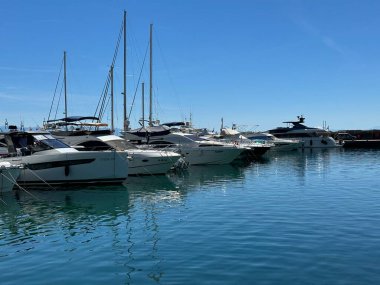 Deniz kenarında yatlar ve tekneler için bir rıhtım. Özel su nakliyesi için bir deniz koyuna park etmek. Hırvatistan 'ın limanı Opatija şehrindeki iskeledeki lüks yatlar, 5 Temmuz 2024
