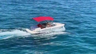 Tekne dalgaları denizin arka planına doğru keser. Bir motorlu tekne mavi denizde yelken açar. Hırvatistan açıklarındaki Adriyatik kıyısında tatiller, Preko adası, 27 Haziran 2024