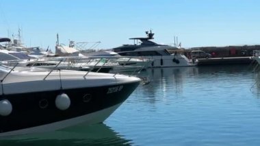 Deniz kenarında yatlar ve tekneler için bir rıhtım. Özel su nakliyesi için bir deniz koyuna park etmek. Hırvatistan 'ın limanı Opatija şehrindeki iskeledeki lüks yatlar, 5 Temmuz 2024