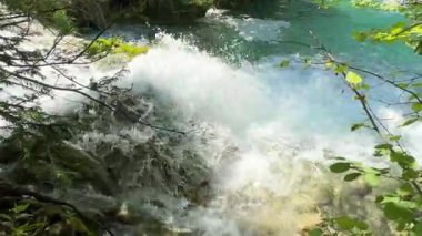 Hırvatistan 'daki Plitvice Gölleri' nde, canlı bir yaz manzarası olan dağlar ve yemyeşil alanda nefes kesici bir şelale, maceracılar ve fotoğrafçılar için doğal bir cennet sunuyor..
