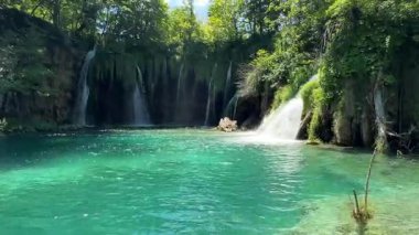 Hırvatistan 'ın Plitvice Gölleri' ndeki çarpıcı şelale, yemyeşil ve görkemli yaz dağlarının zemininde çağlayarak, açık hava keşifleri için mükemmel bir manzara sunuyor..