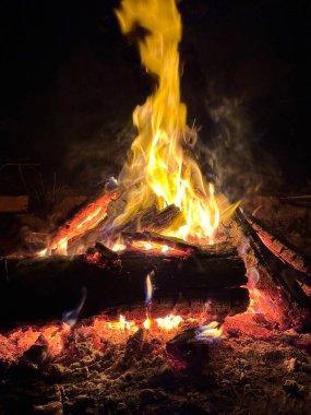 Sıcak, davetkar bir kamp ateşi, insanları büyüleyici parıltıya daha da yaklaştırarak, hatıralar ve kahkahalar için mükemmel bir ortam yaratarak, alevler içinde dans ve çatırtı ile karanlık geceyi aydınlatır..
