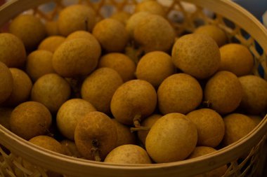 Longan satılmayı bekleyen bir sepete koydu...