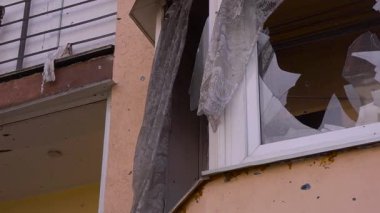 Rüzgarda dalgalanan perdeli kırık pencere gizemli ve şüpheli bir hikaye için ürkütücü bir ton oluşturur. Tahta, tuğla ve beton elementleri şüpheli ortamı güçlendirir.