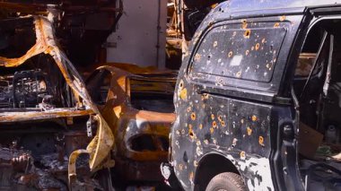 Çatışma içindeki bir şehir, yanan arabaların olduğu bir postapokaliptik dünya gibi, kurşunlarla delik deşik edilmiş bir minibüs, kentsel çürüme sahneleri.