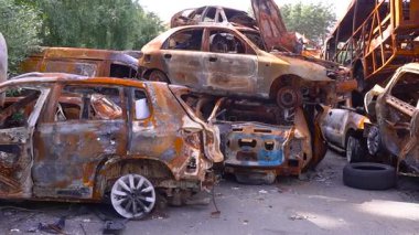 Hurdalıkta paslanmış araba enkazı, yangından kalan enkaz kalıntıları, kazadan kaynaklanan yıkım ve yıkım belirtileri.