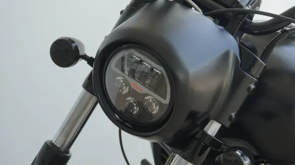 Bu, modern tasarımı ve karmaşık mühendislik detaylarını sergileyen motosiklet farının parlak bir yakın plan görüntüsü.