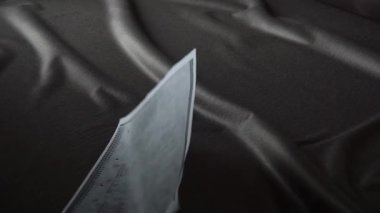 Detaylı bir plan, karmaşık tasarım ve kavramların vurgulandığı, zengin, koyu renk bir kumaş zemin üzerinde sergileniyor.