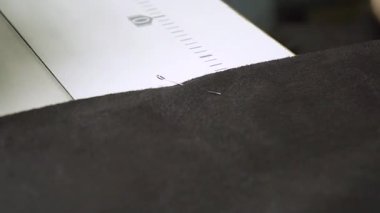 Bu kumaş ve iğne yerleştirmenin yakından incelenen bir ayrıntısıdır. Tekstil çalışmalarında yüksek hassasiyeti gösterir.
