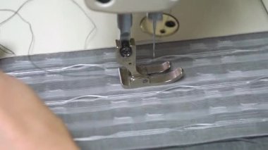 Çeşitli kumaş türlerine özel dekoratif dikişler yapan bir dikiş makinesinin yakın plan görüntüsü