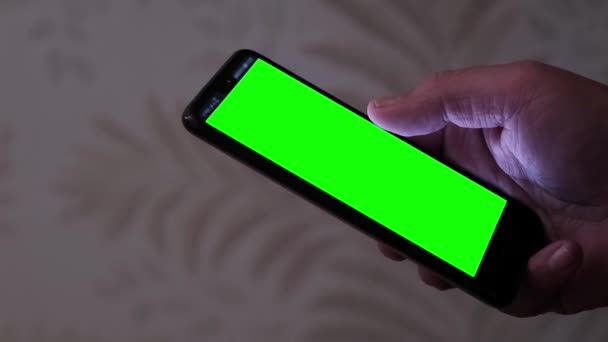 一个男人手里拿着智能手机 手里拿着一个发光的绿色屏幕 — 图库视频影像