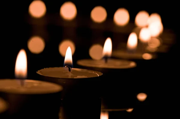 Eine Reihe Brennender Kerzen Auf Einem Tisch Der Dunkelheit Großaufnahme — Stockfoto