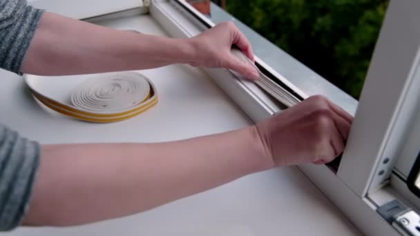 Preparing Cold Season Woman Sticks Dark Rubber Sealing Tape Window — Stock Video