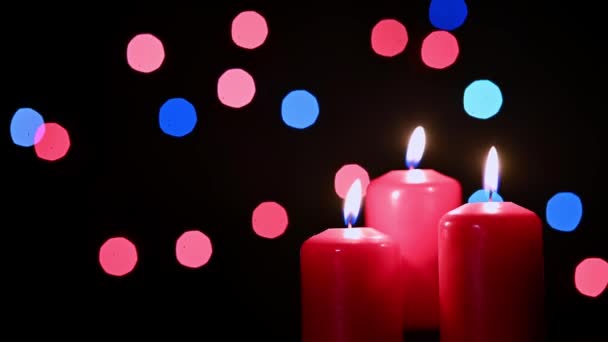 三支燃烧的红色蜡烛 背景上闪烁着模糊的闪光的花环 — 图库视频影像