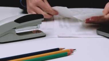 Bir iş kadını elinde para makbuzları tutar ve onları zımbayla zımbalardı..
