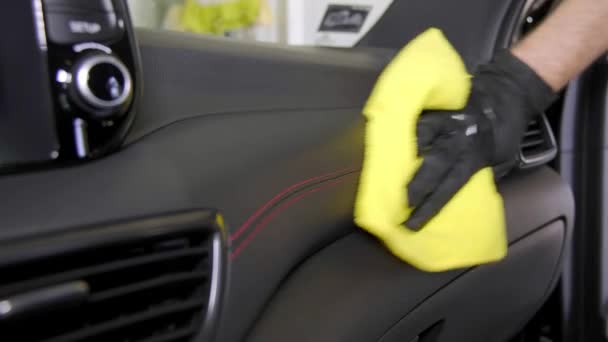 手袋の男性の手は黄色のラグで車をきれいにし 黒い車のダッシュボードを磨く — ストック動画