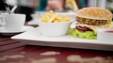 Biftek burger ve patates kızartması bir bar barında masada..