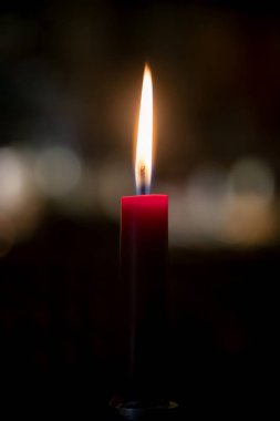 Burning Christmas candle on a blurred background, intimate setting with a festive mood