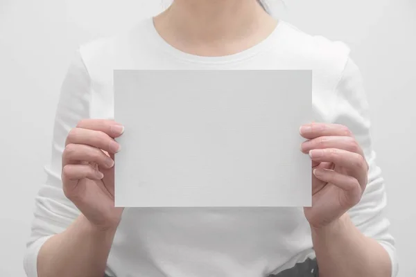 female HR manager offers job by showing you blank paper mockup for your promotional content.