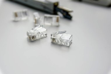 close-up of several rj45 connectors and other tools on a white table.