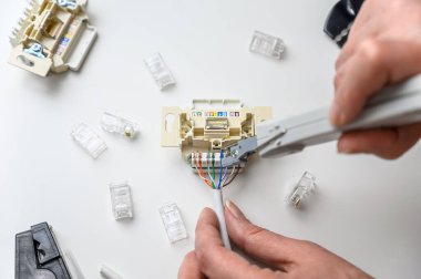 Mounting the RJ45 module, attaching the wire to the computer socket in the room.