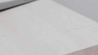 Adam tahtada işaretler yapıyor. Tahta ve el testeresiyle çalışmak. Marangozluk işi.