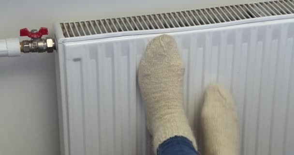 Voeten Van Een Vrouw Witte Gebreide Sokken Verwarmen Bij Verwarming — Stockvideo