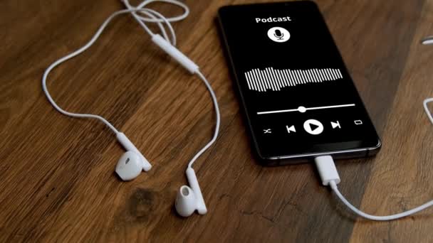 Cep Telefonunda Podcast Uygulaması Masada Kulaklık Olan Akıllı Telefon — Stok video