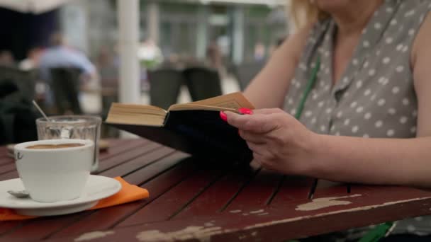 Uma Mulher Sentada Uma Mesa Com Livro Uma Xícara Café — Vídeo de Stock