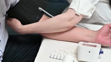 Yetişkin bir adamın evdeki kan basıncını elektronik tonometre ile ölçmesi..