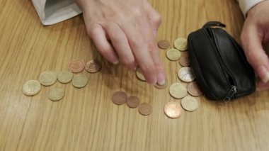Bir kadın eli ve biriktirmek için bir yığın bozuk para. para biriktirme kavramı.