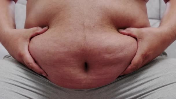 不健康な脂肪の男の概念を示すために彼のチャビー腹を運ぶ肥満 — ストック動画